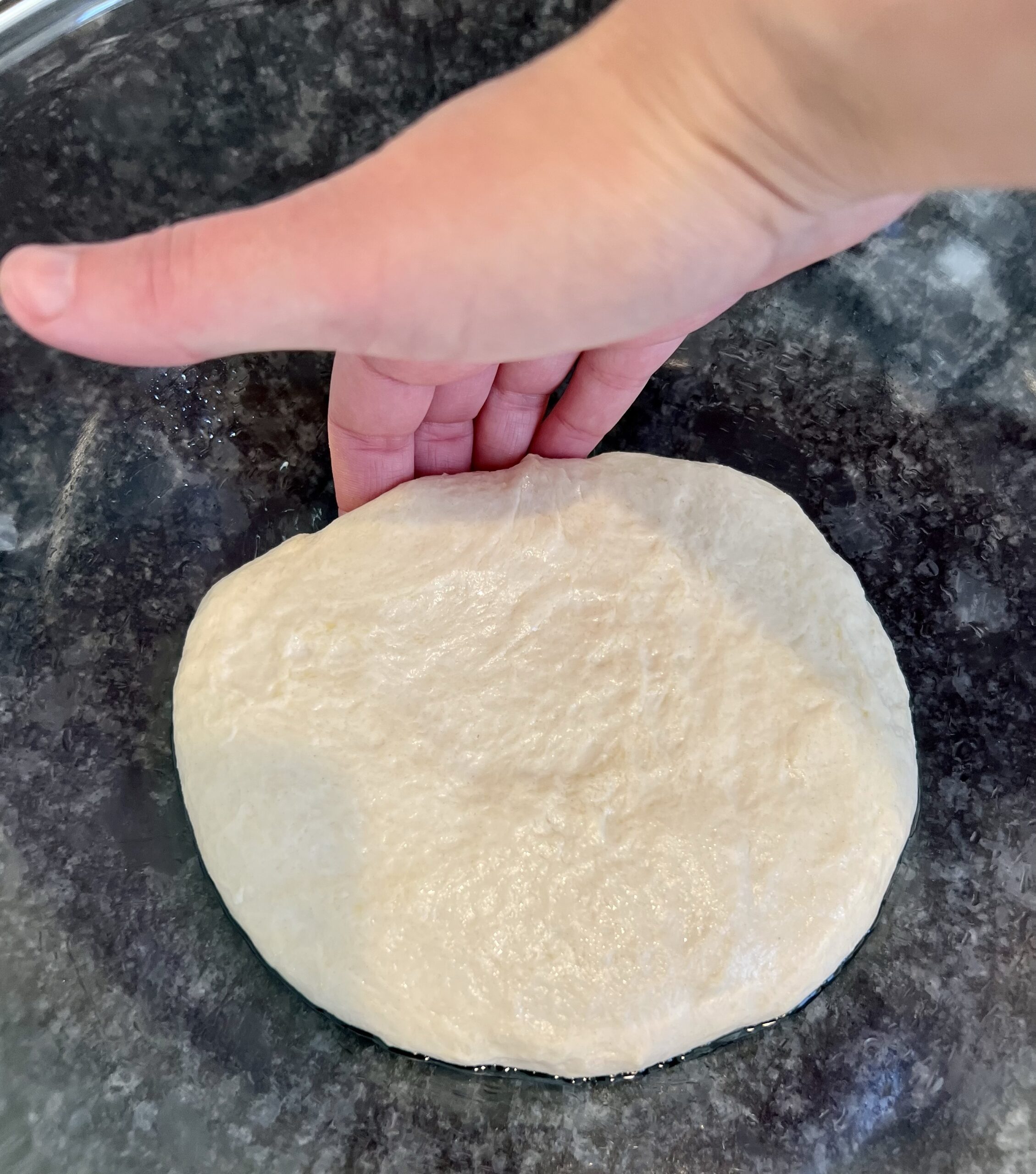 sourdough pizza crust - Place hand under a portion of the dough