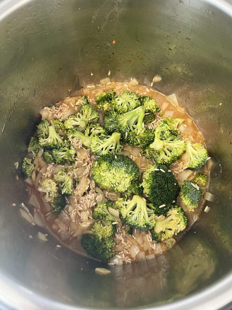 Add rice, broth, & broccoli, stir, and top with the chicken thighs