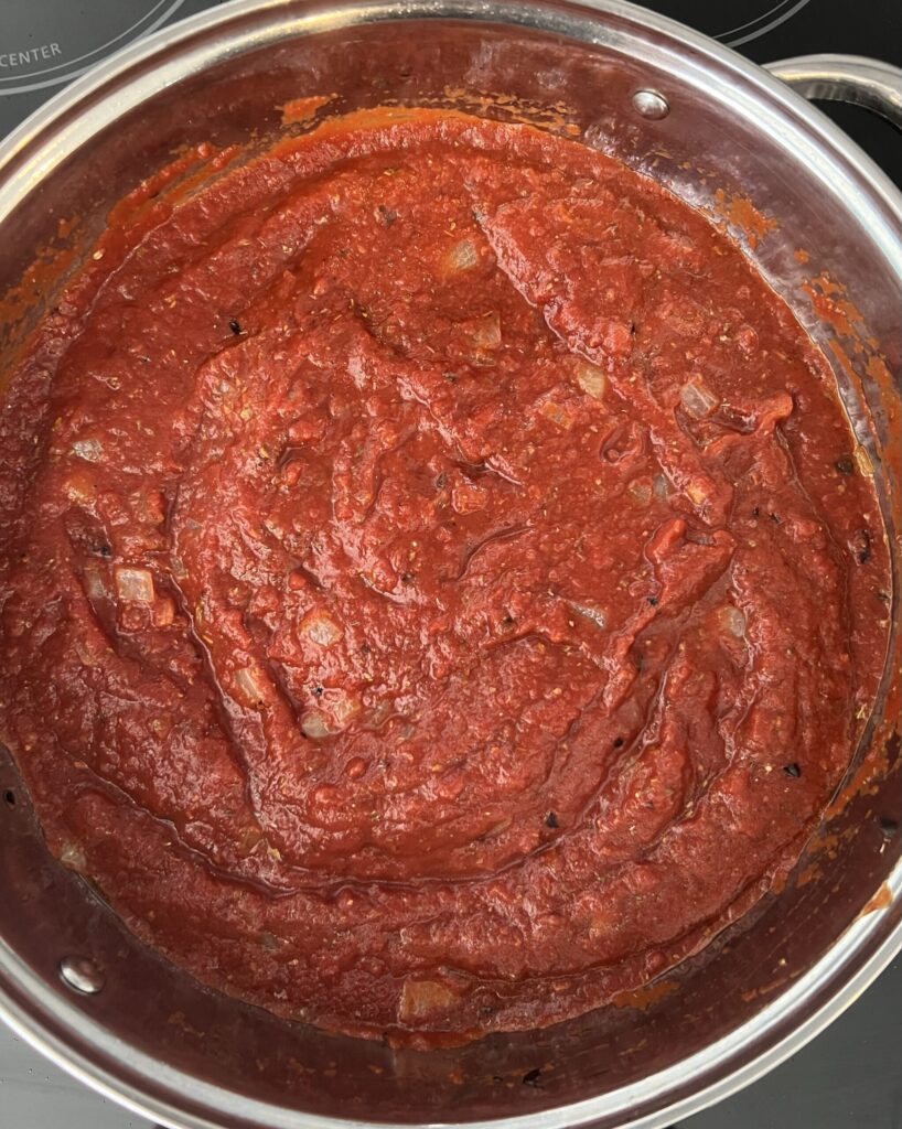 Next, add tomatoes, salt, pepper, and oregano 