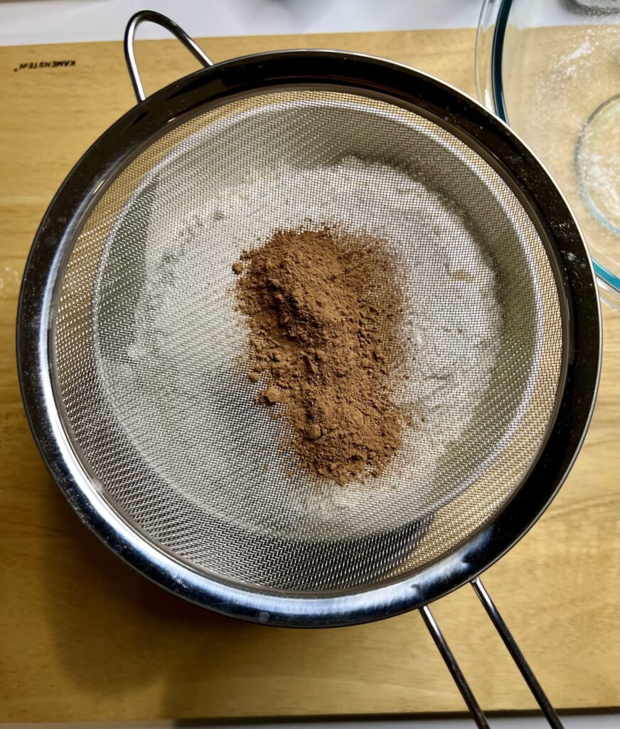 In a separate bowl sift together the bread flour and cocoa powder and then add it to the liquid mixture. 