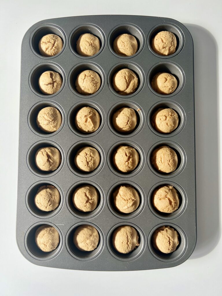 Once baked, press the peanut butter cup into each dough ball