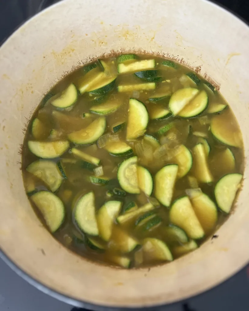 Lastly, pour the broth into the pot and bring to a boil. Reduce the heat to a simmer, cover the pot, and let it cook for 15-20 minutes or until the zucchini is tender. 