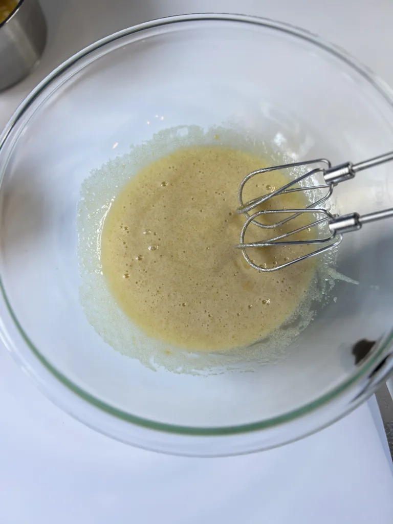 In a large mixing bowl beat together the melted butter and sugar until creamy. 