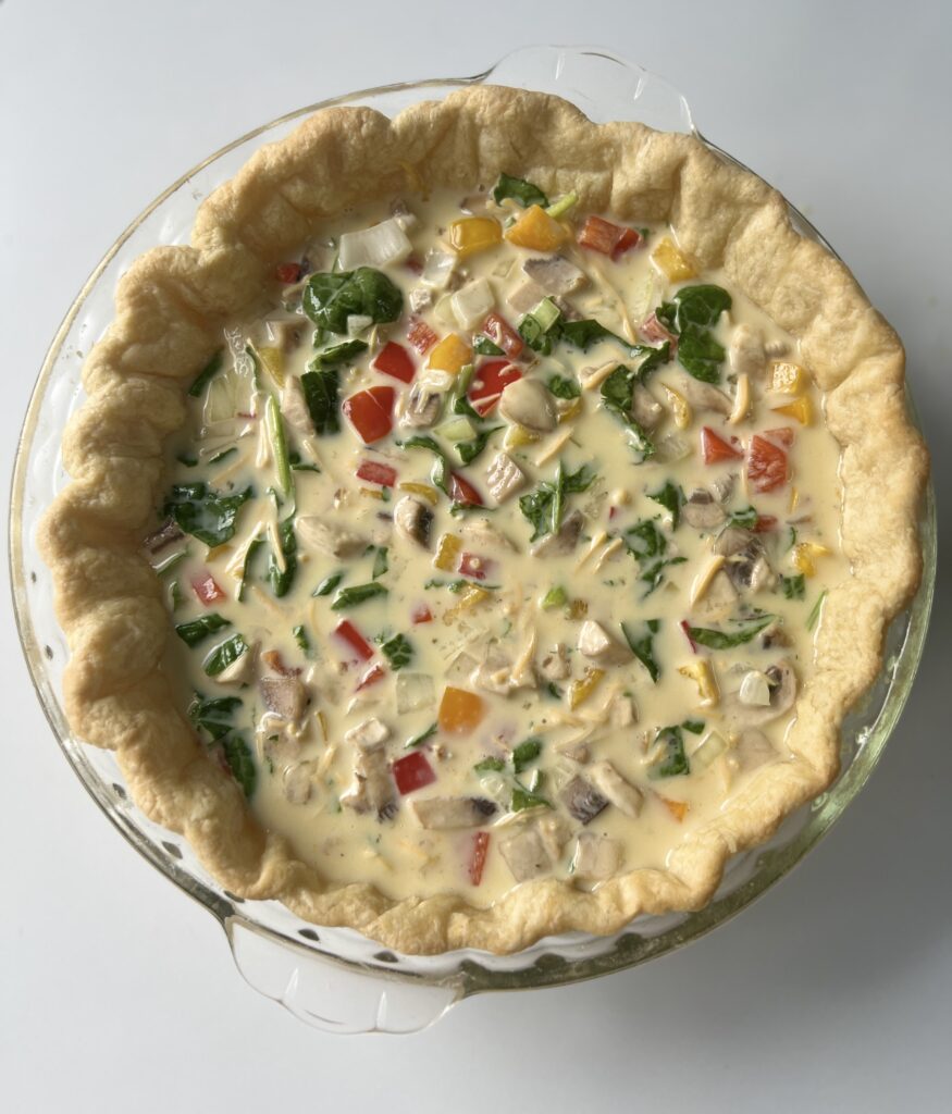 Pour the quiche filling into the pie crust (it is okay if it is warm) until almost full. Be careful not to fill it to the brim as it could overflow. 