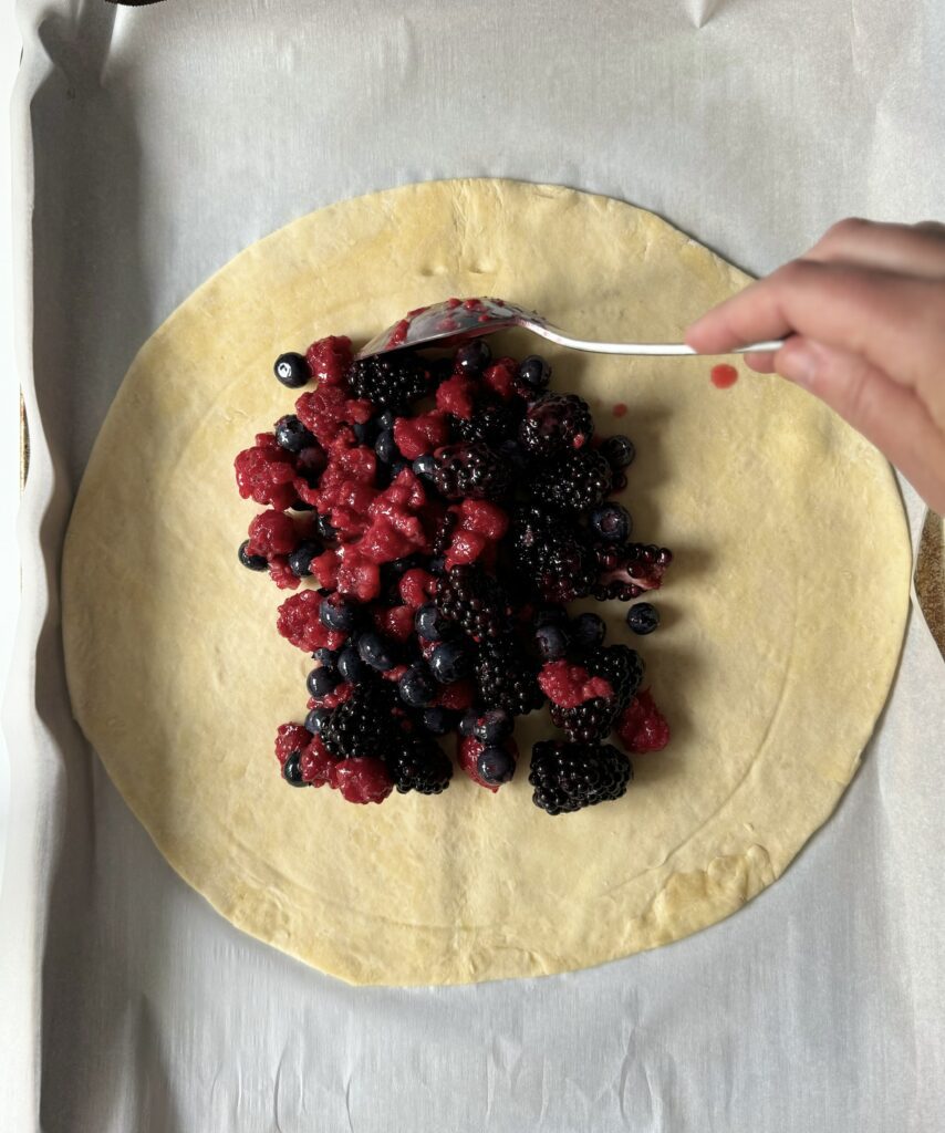 placing fruit into the berry galette