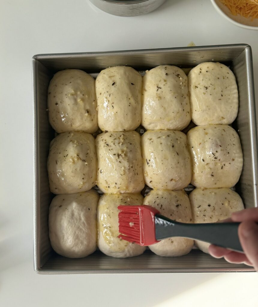 brushing sourdough cheese buns