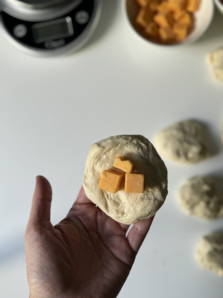 adding cheese to sourdough cheese buns