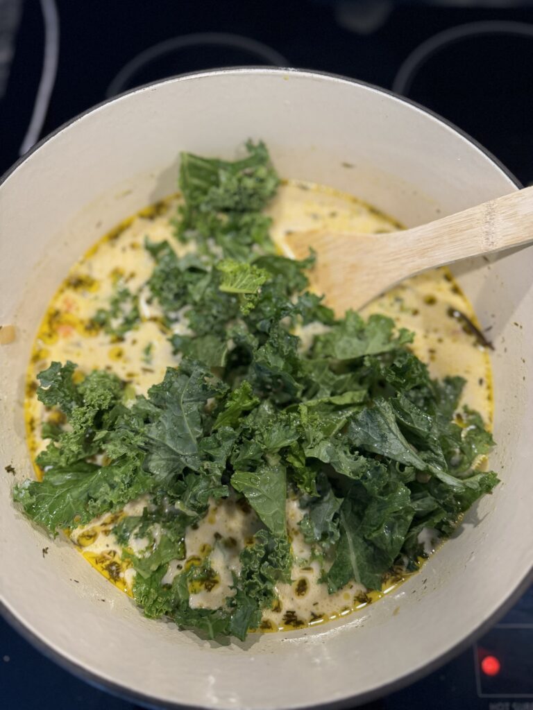 adding kale to wild rice autumn soup