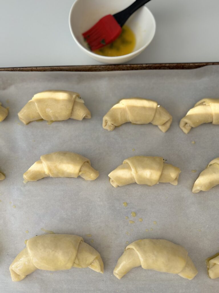 brushing stuffed crescent rolls with butter