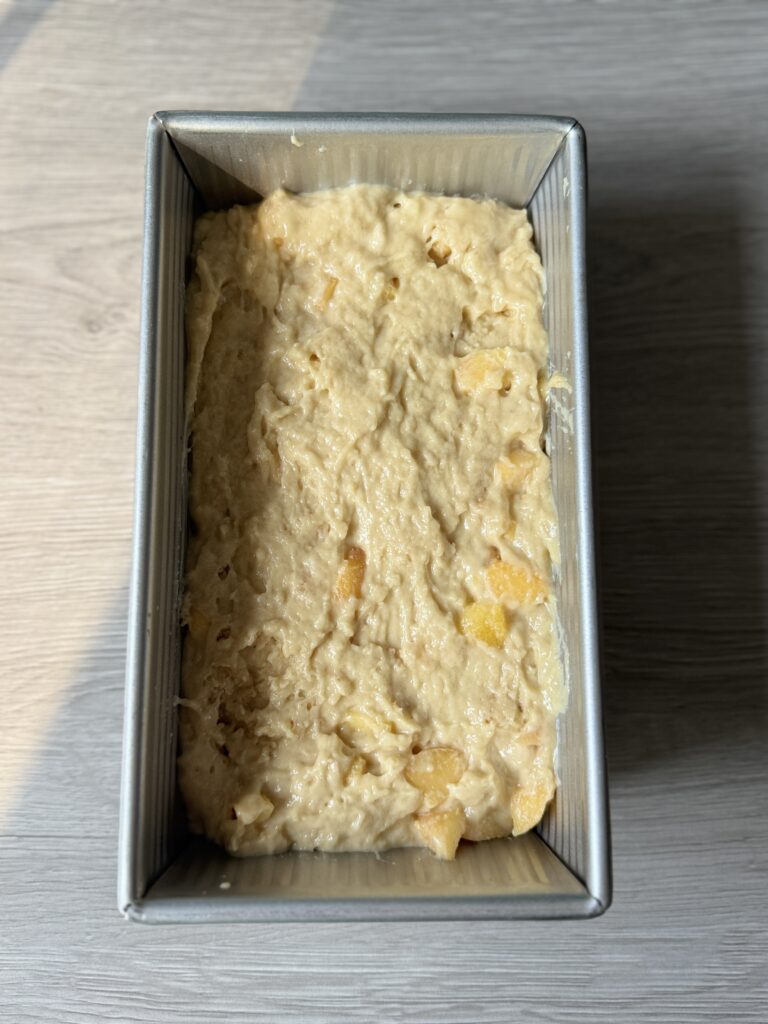 sourdough peach bread batter in the loaf pan