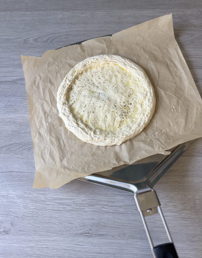 transferring pizza crust to bake