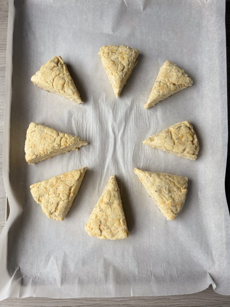 shaped rosemary cheddar sourdough scones on pan