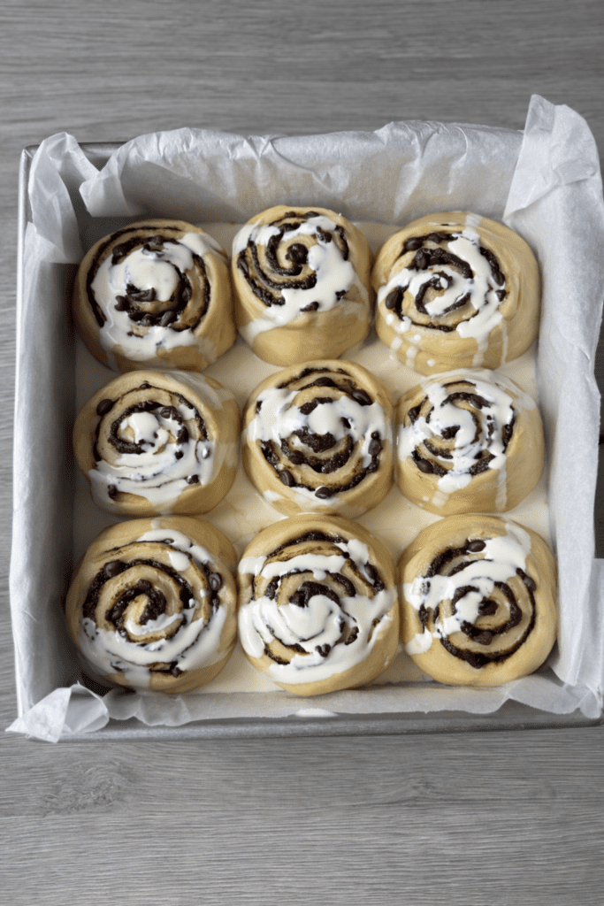 cream bath on chocolate chip sourdough cinnamon rolls