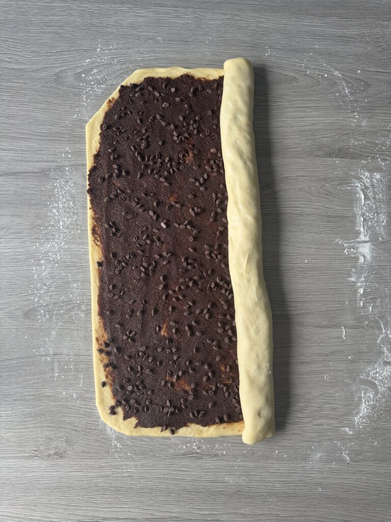 shaping chocolate chip sourdough cinnamon rolls